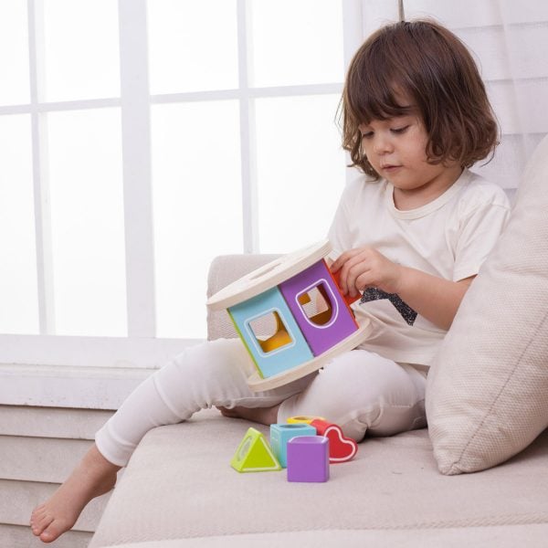 ילדה על ספה משחקת בקוביית חודשים צעצוע התפתחות
