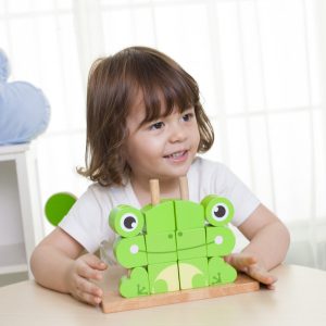 ילדה משחקת בקוביות להרכבת צפרדע