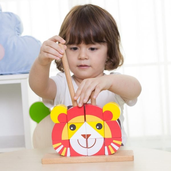ילדה משחקת בקוביות להרכבה בצורת אריה