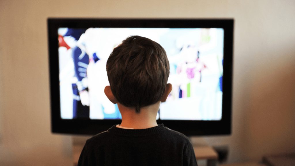 ילד בוהה במסך טלווזיה שידוע כהורס יצירתיות אצל ילדים