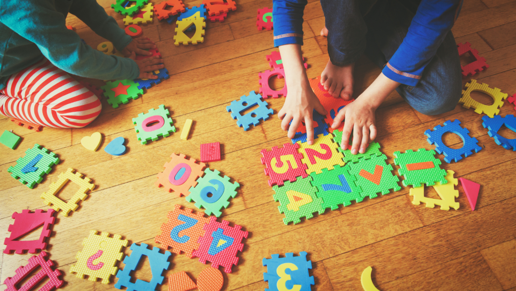ילדים משחקים במשחק צבעוני על רצפת עץ