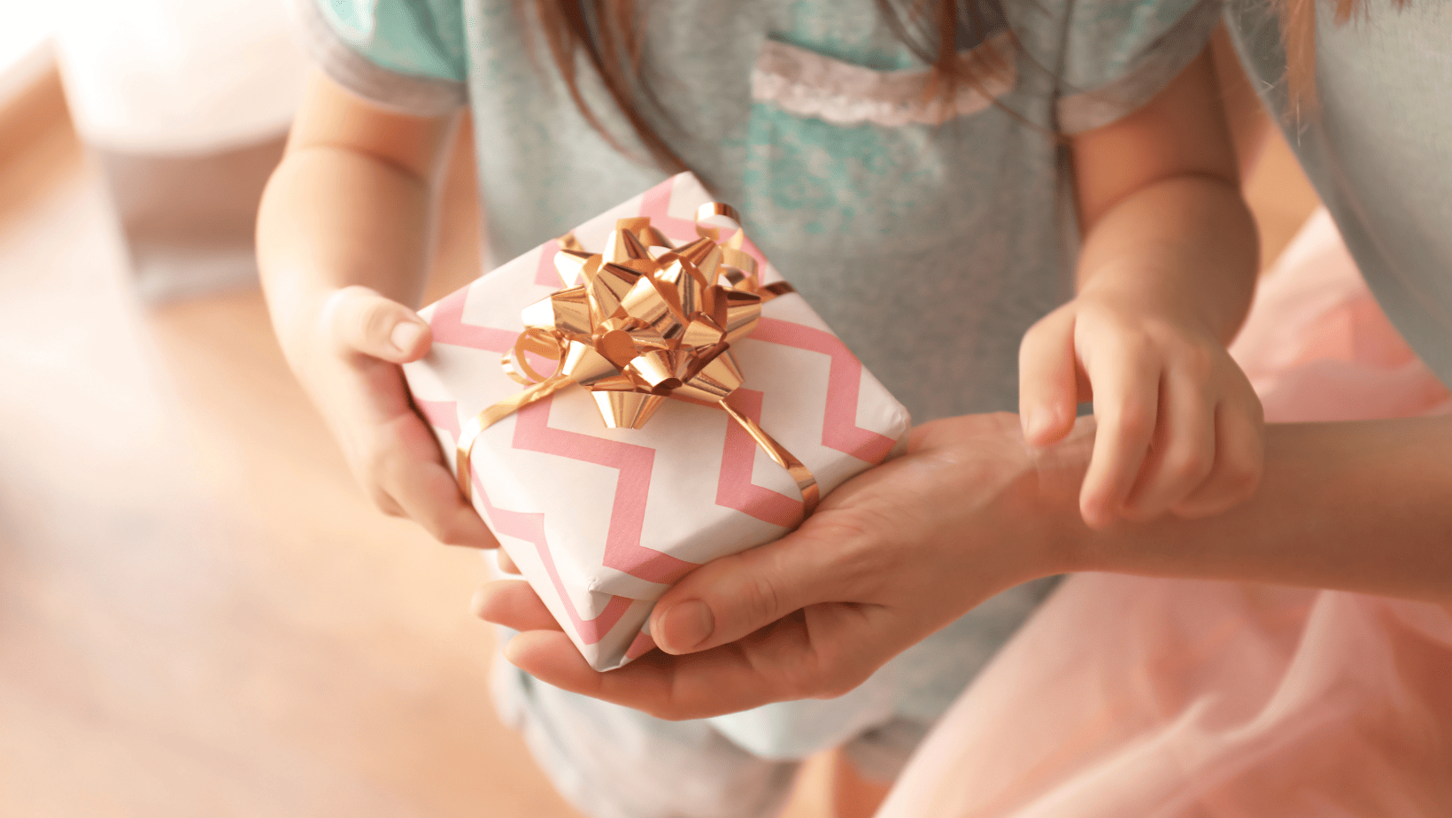 ילדה מקבלת מתנה לגיל 7 בעטיפה ורודה